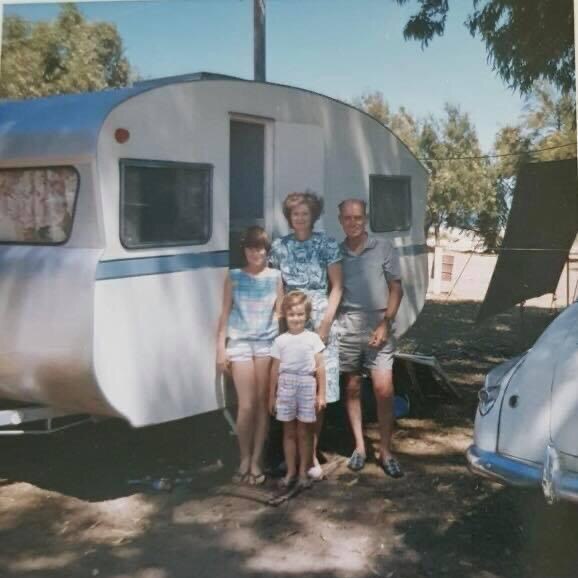 A 1960's family standing in front of their caravan.