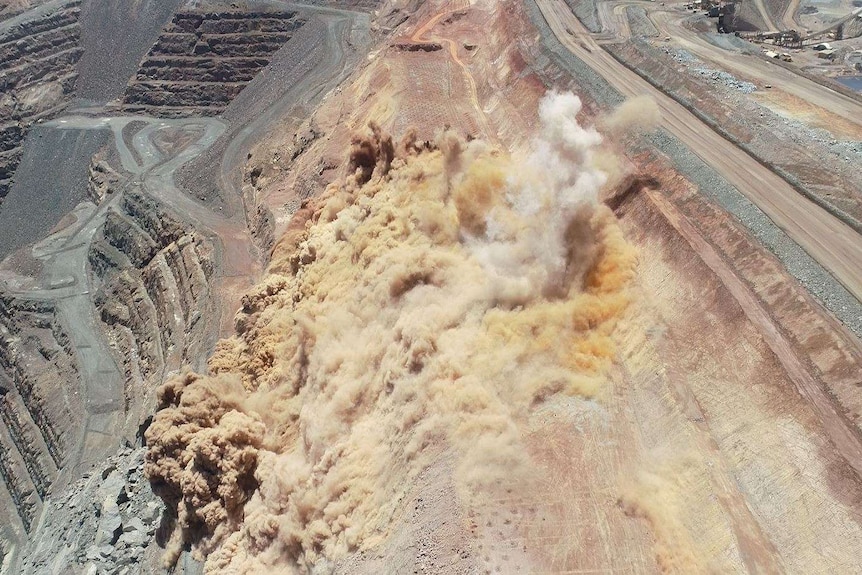 A drone view of an open pit mine blast.