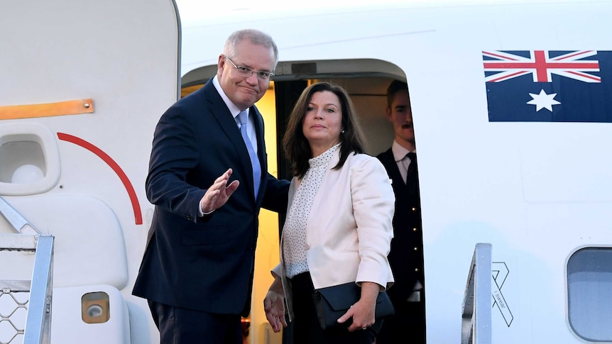 Scott and Jenny Morrison board a jet.