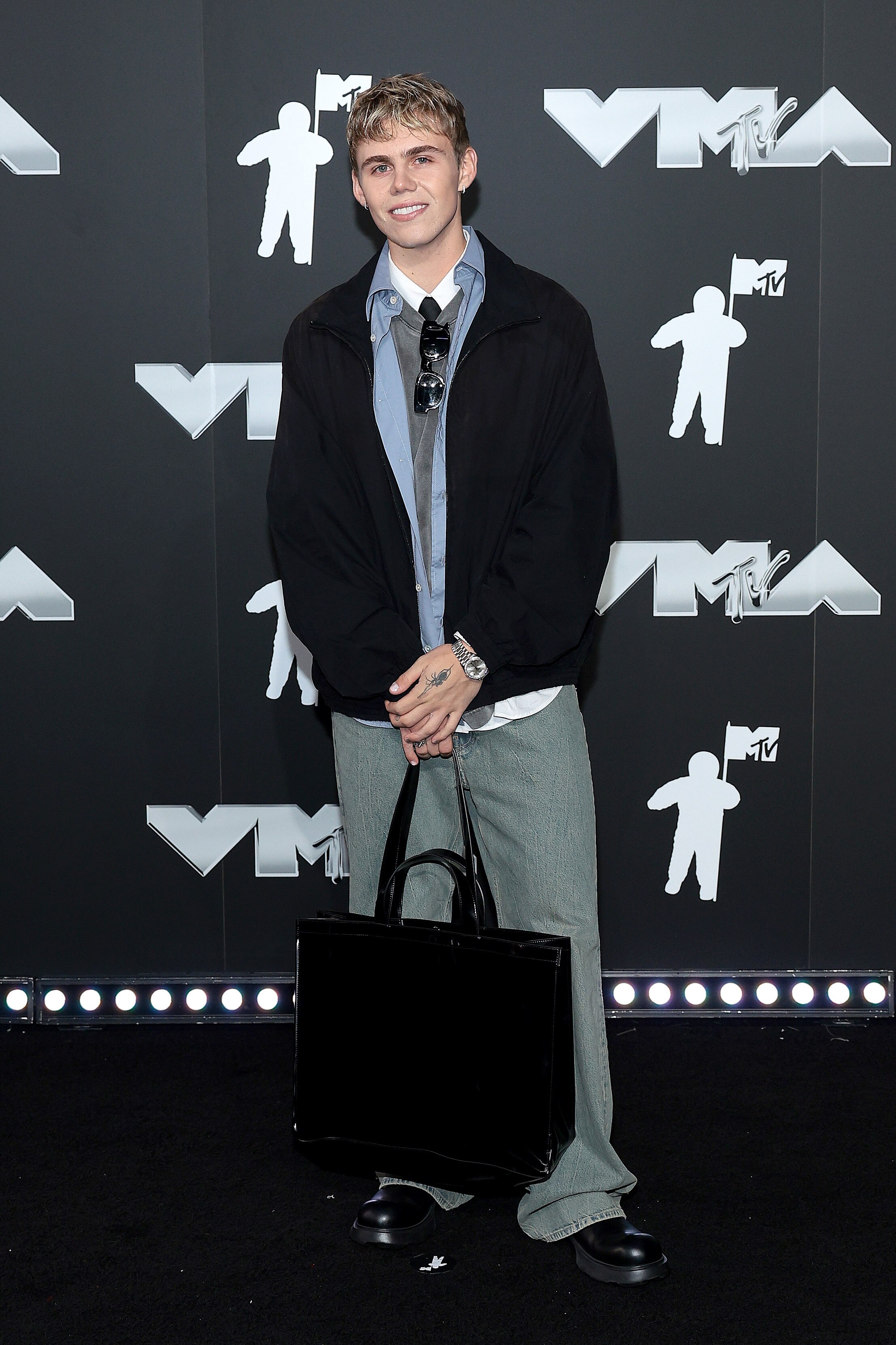 The Kid Laroi wearing a normal every day outfit of pants and shirt and jacket