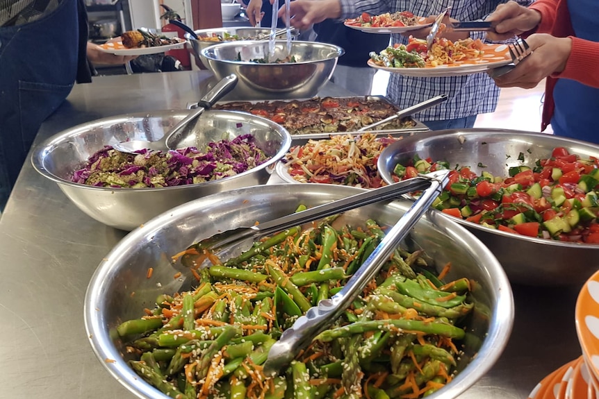 Several bowls filled with salads and fresh vegetarian food on the table
