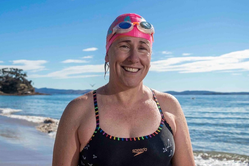 Bronwen Puleston-Jones looks to the camera while standing on a beach.