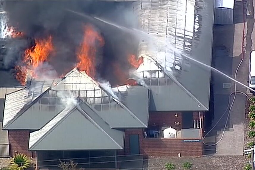 Aerial image of flames in the roof of a building.