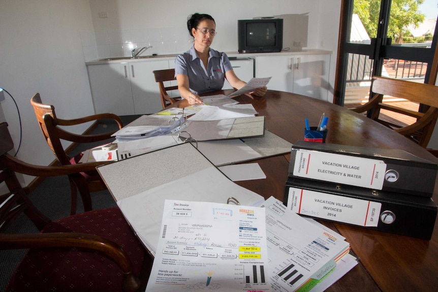woman at a table with lots of paperwork