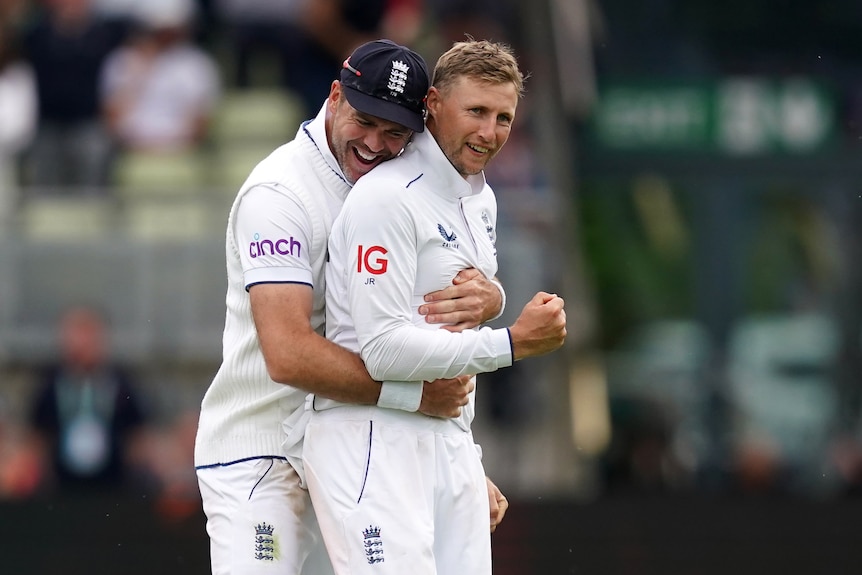 England bowler Jimmy Anderson hugs teammate Joe Root from behind in the first Ashes Test.