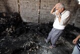 Libyan man looks at charred skeletons
