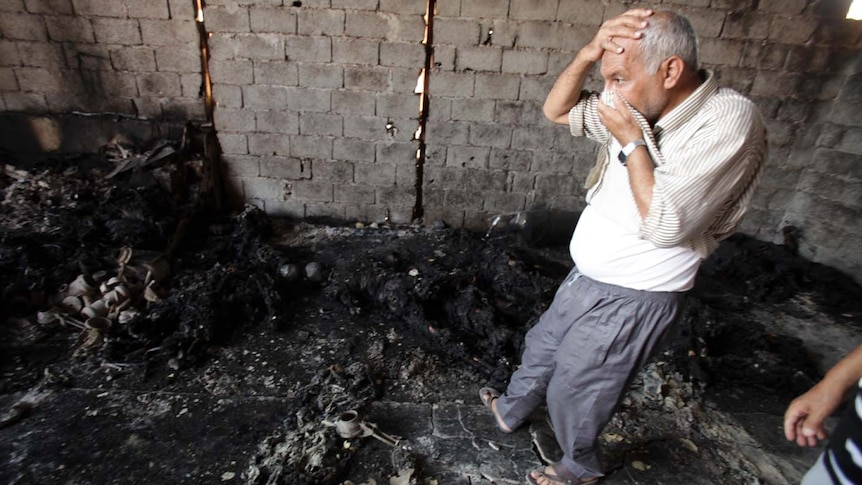 Libyan man looks at charred skeletons