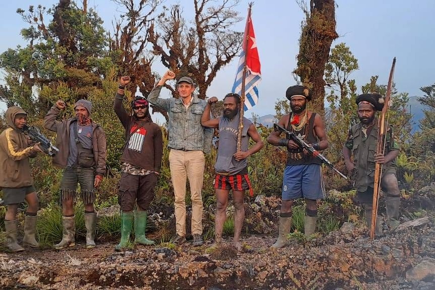 A hostage raises his arm in solidarity with Papua rebel fighters.