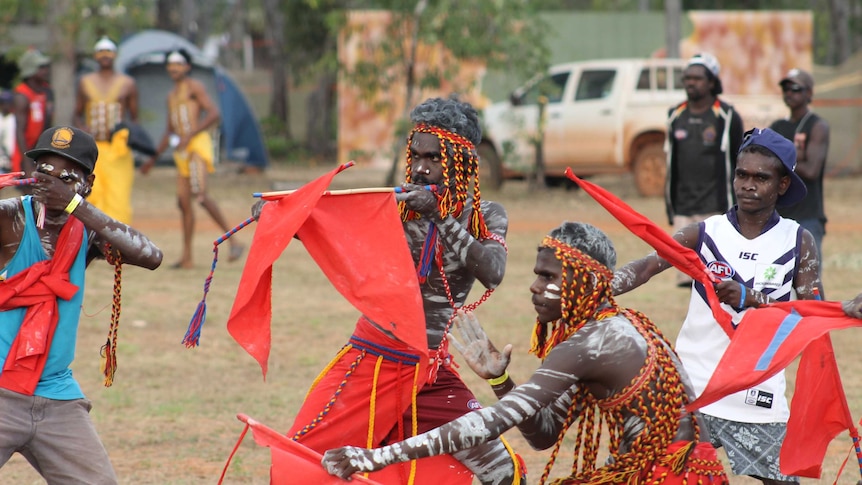 Aboriginal dancers posing with red flags