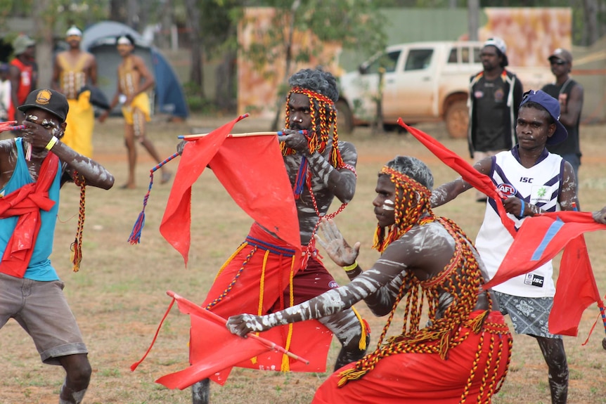 Aboriginal dancers posing with red flags