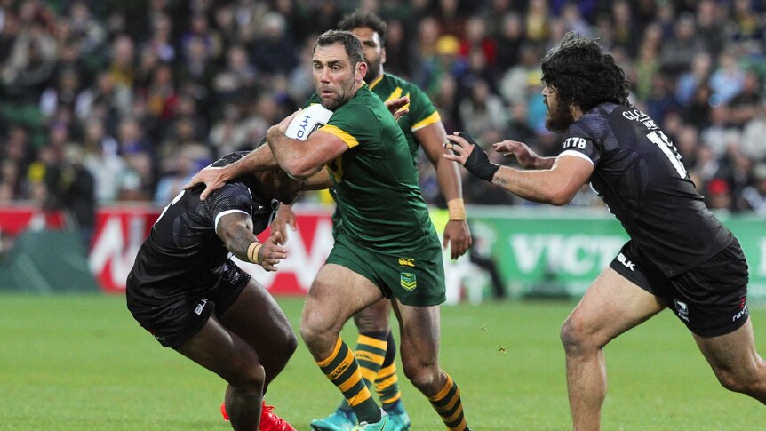Kangaroos player Cameron Smith tries to evade two New Zealand defenders.