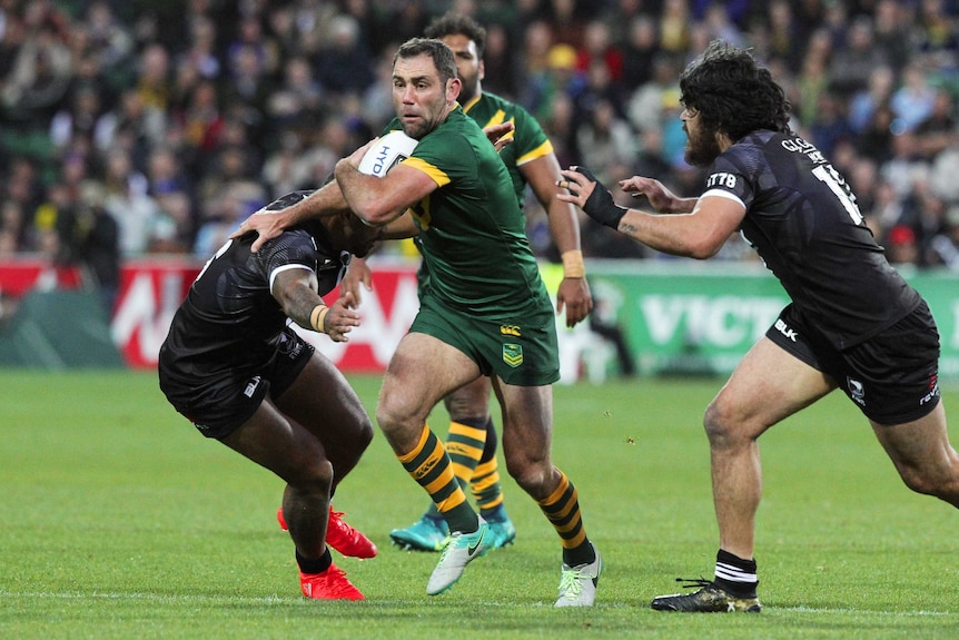 Kangaroos player Cameron Smith tries to evade two New Zealand defenders.