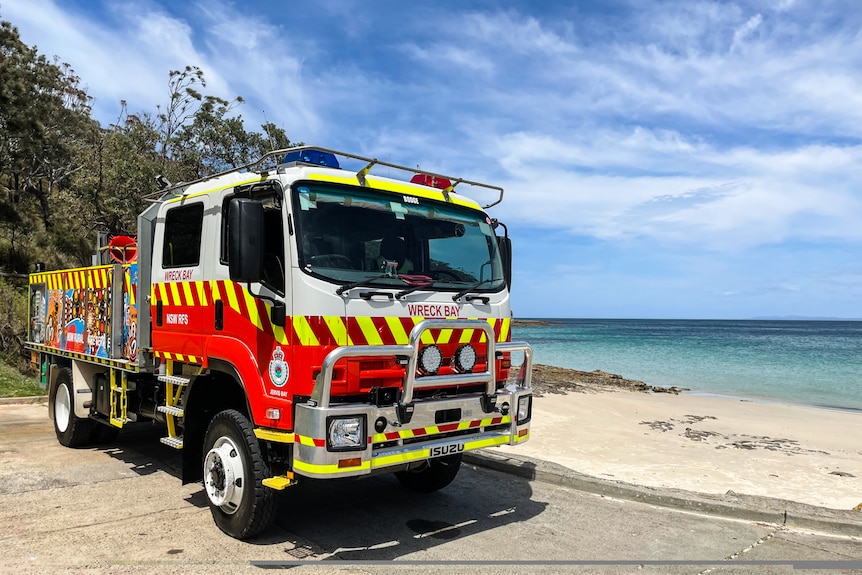 A fire truck on a pristine beach.