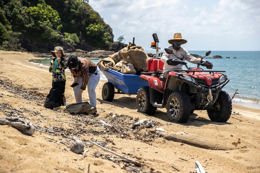 Quadbike and trailer with volunteers on a scenic beach