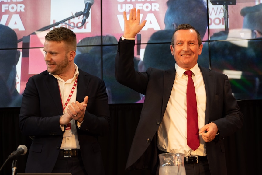 A mid-shot of Mark McGowan smiling and waving to the crowd at a Labor conference.
