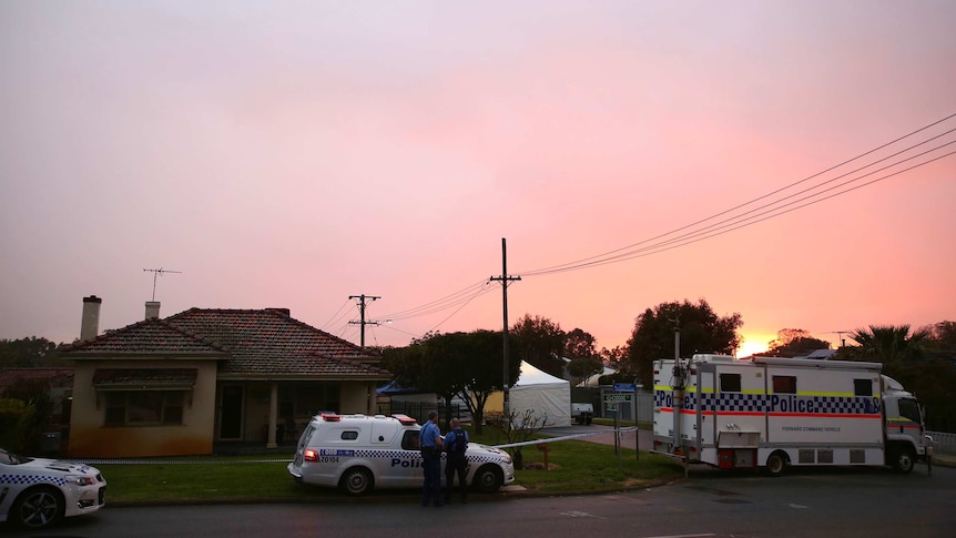 A mobile police van and patrol vehicle in front of the house, where the bodies of two women and three children were found.