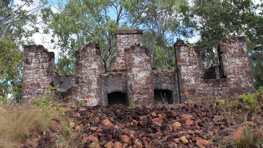 Brick ruins of a former British colony, lined with eucalyptus trees.