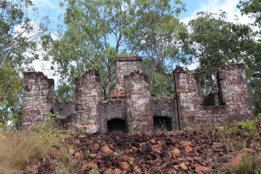 Brick ruins of a former British colony, lined with eucalyptus trees.