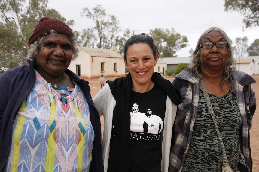 Three women stand in the outback