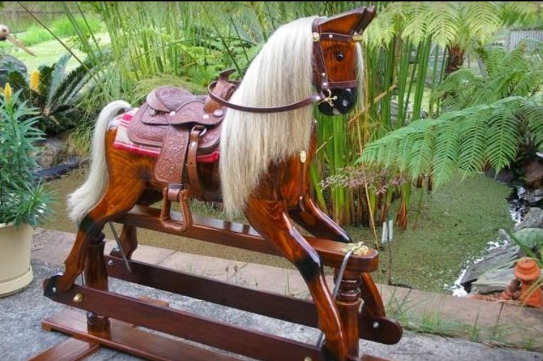 A beautiful rocking horse in a garden setting.