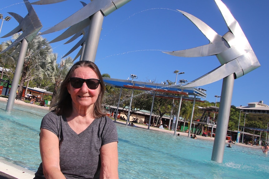 Mme Socrates devant le lagon et la sculpture de poissons sur l'esplanade de Cairns. 