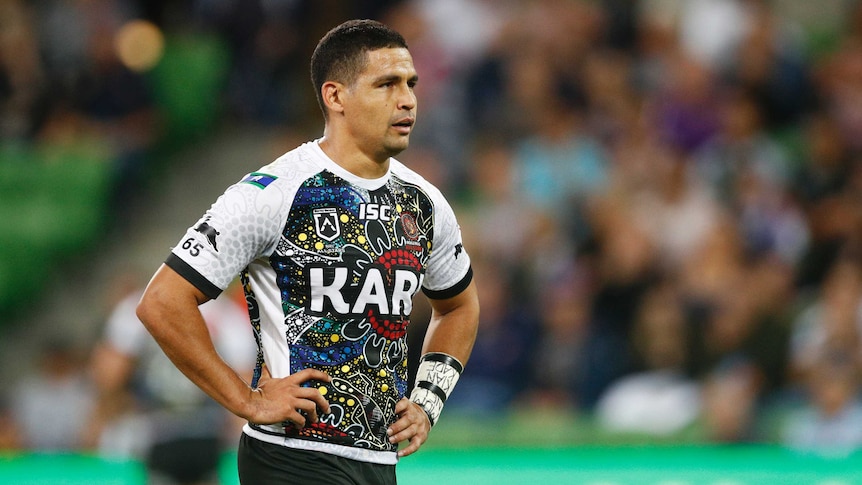 Cody Walker stands with both his hands on his hips wearing an Indigenous jersey