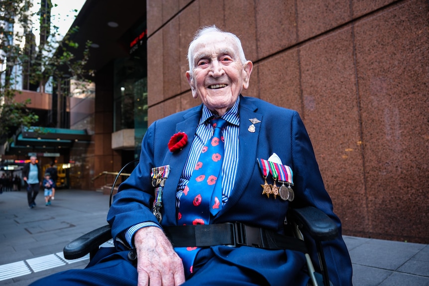 An older man in a wheelchair with service medals.