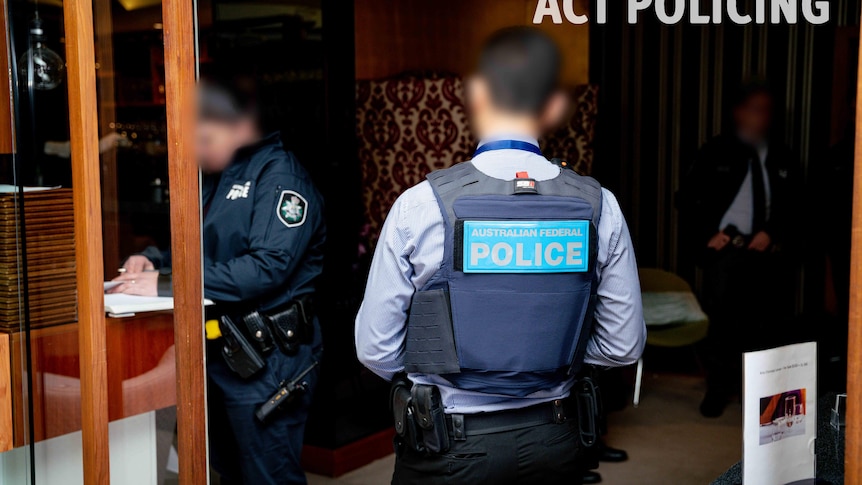 Two anonymous policemen walk into a Canberra restaurant