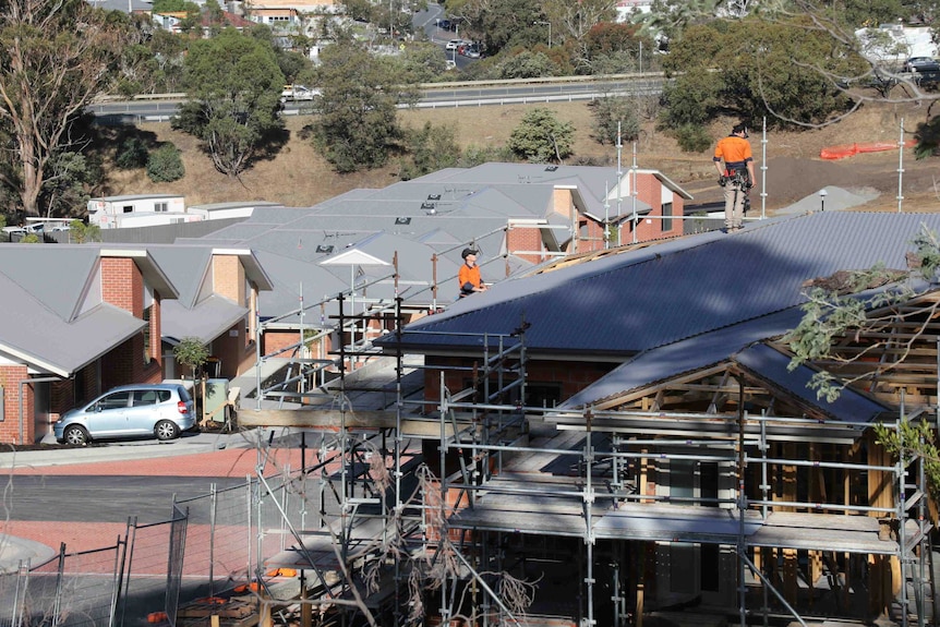 Rows of new houses are being built on the edge of Hobart. One row is complete, another is under construction