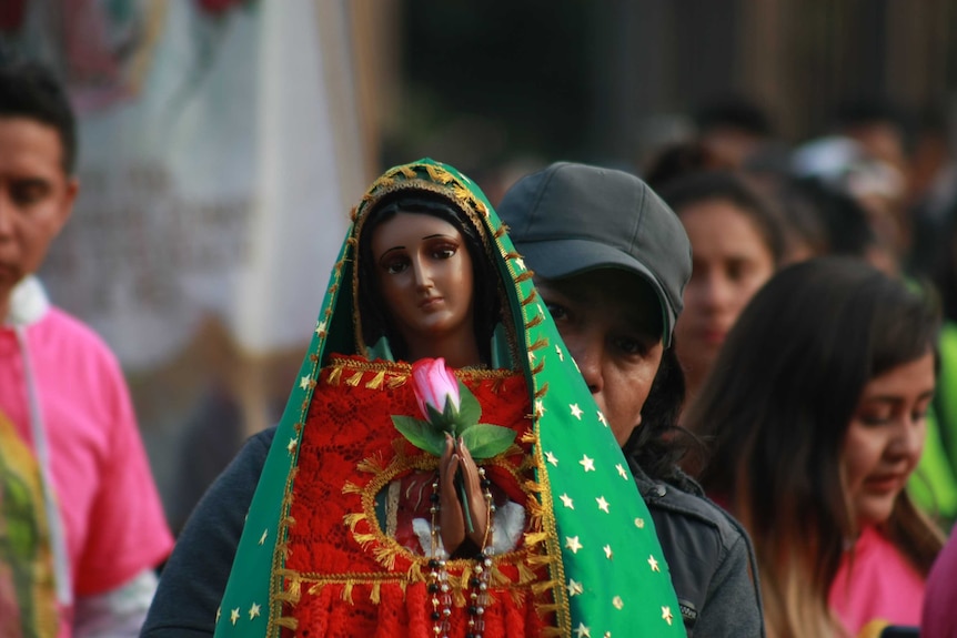 A Mexican Catholic holds up a Virgin of Guadalupe statue, as part of the feast of the virgin, in Mexico City.