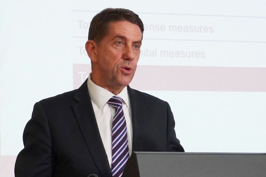 Queensland Treasurer Cameron Dick speaks at a lectern at a media conference.