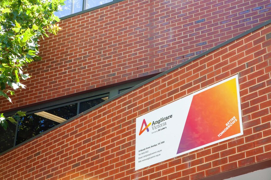 a sign reads anglicare victoria on the building