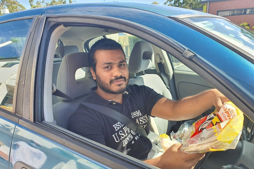man in car with flat bread