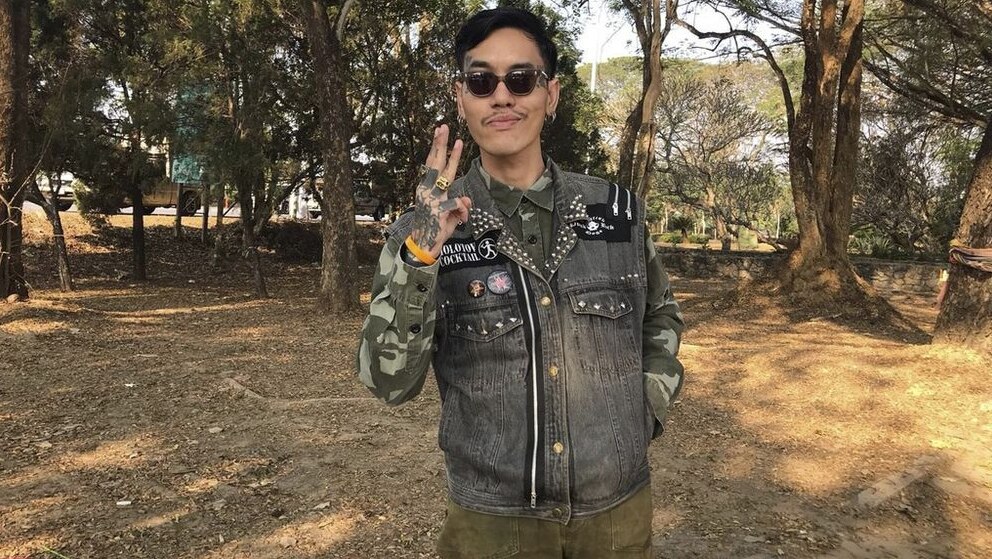 Political activist Mongkhon Thirakot flashes the pro-democracy gesture of a three-finger salute.