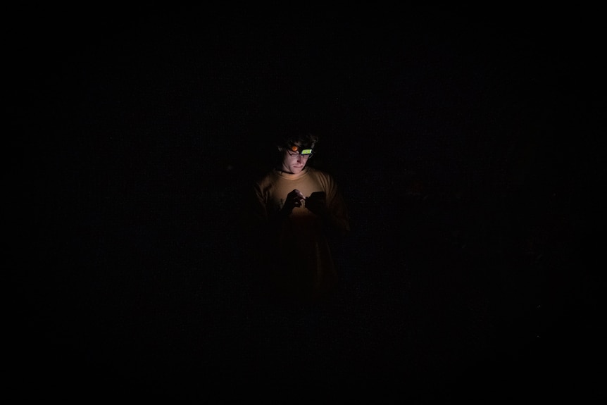 MAN WITH REFLECTION AND HEAD TORCH
