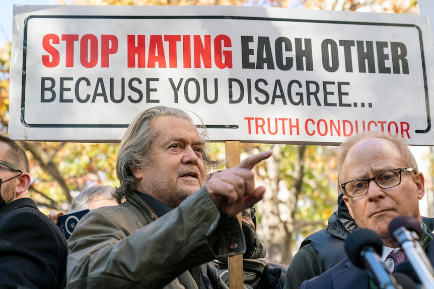 Steve Bannon and his attorney speak with reporters in front of a group of supporters.