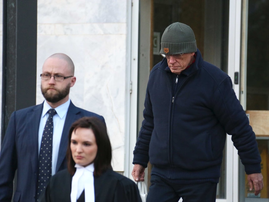 David Eastman (in beanie) walks down the ACT Supreme Court steps with his lawyers.