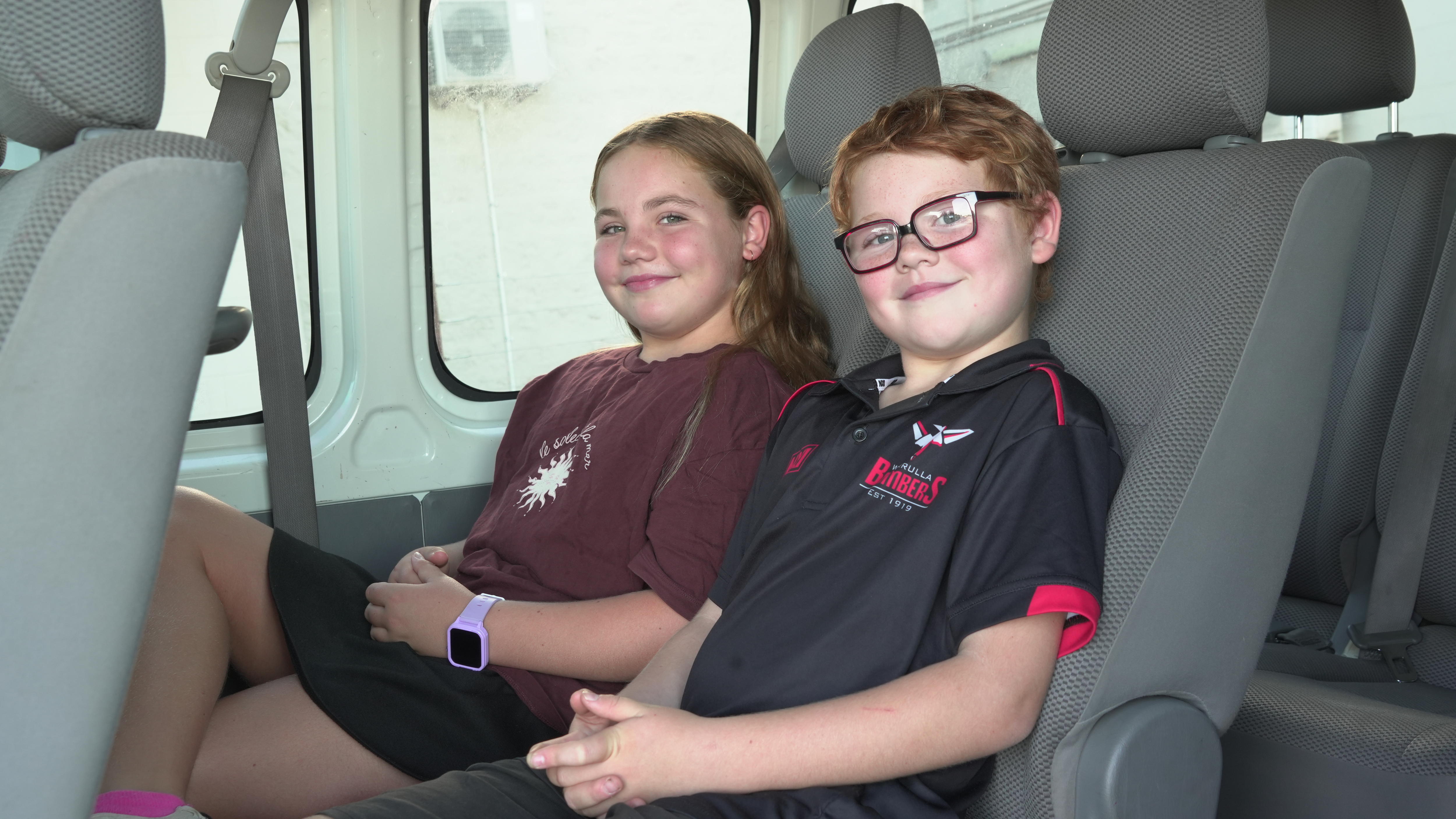 Duas garotas sentadas em um assento em um micro-ônibus