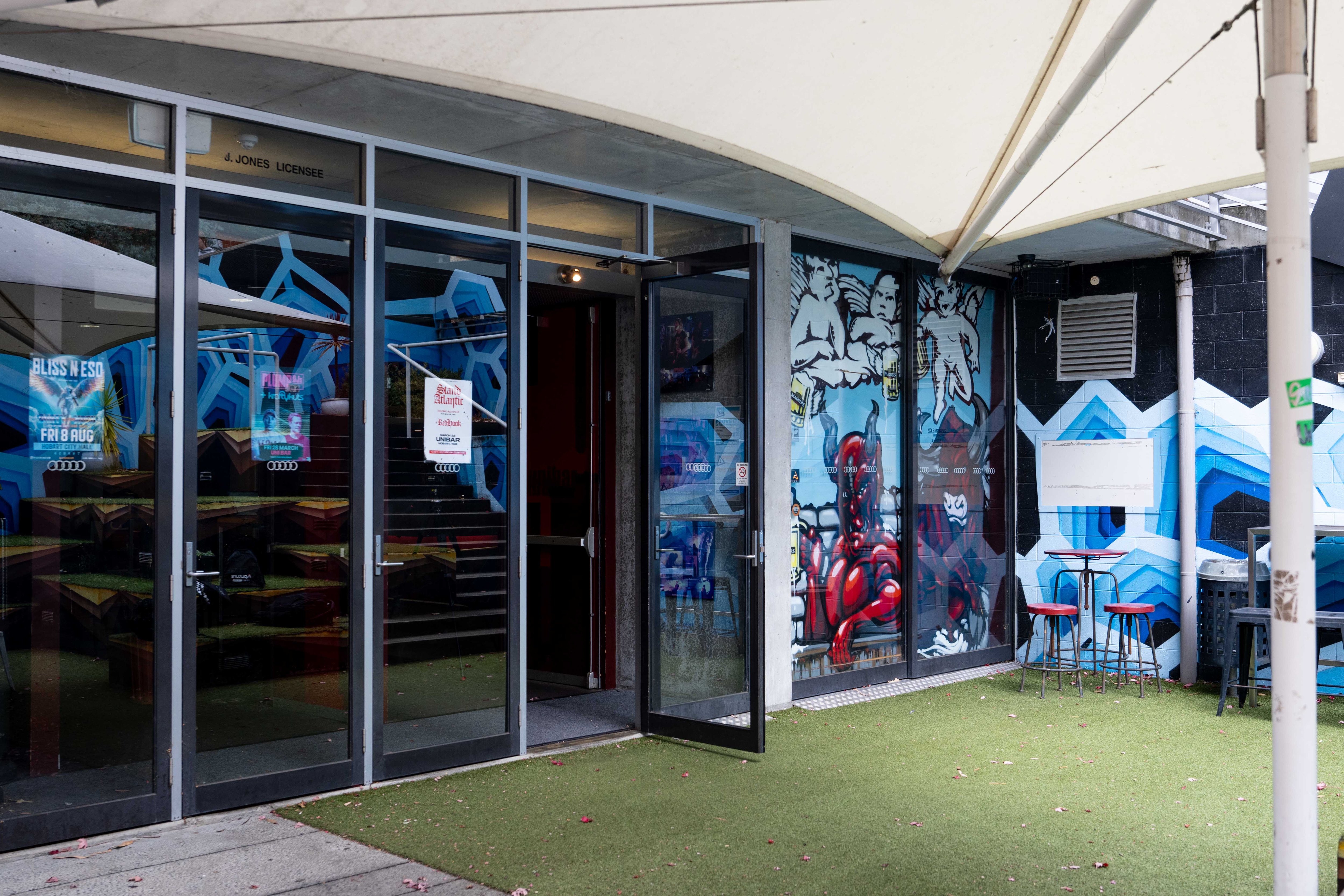 Exterior of building with glass windows and music posters