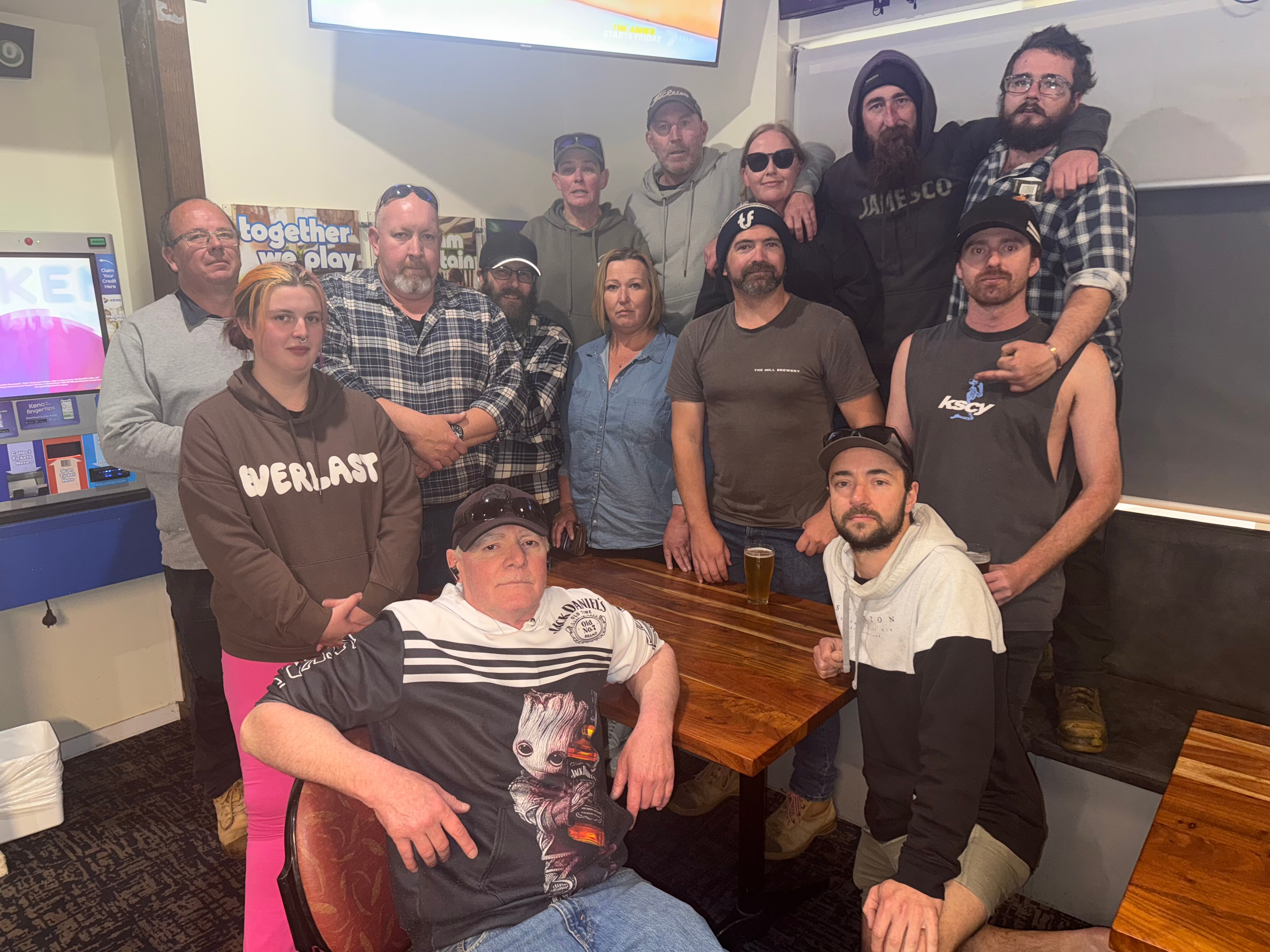 Imagem de um grupo de pessoas sentadas dentro de um pub. 