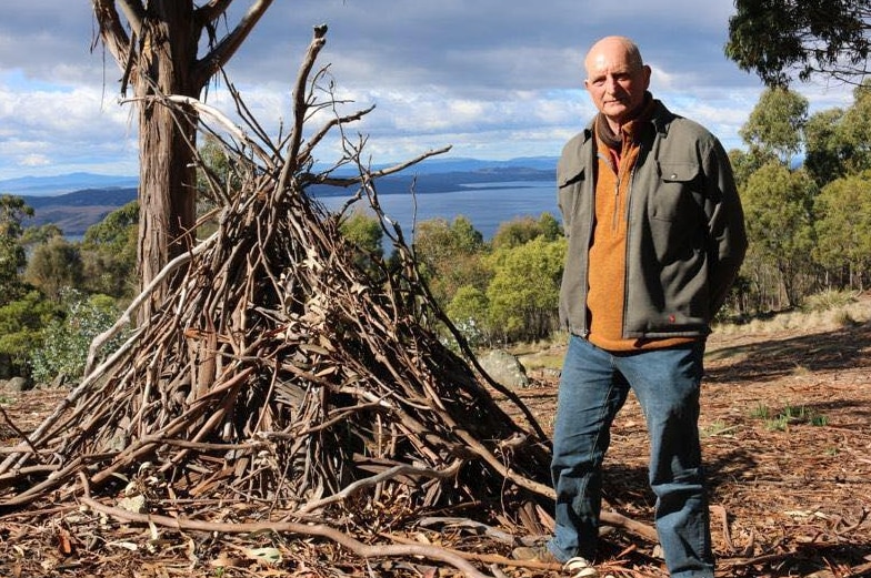 Professor David Bowman standing next to a pile of sticks.
