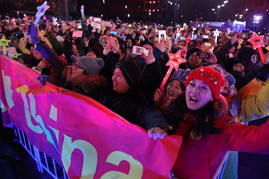 Revellers holding phones and glowing stars count down to the new year in Beijing
