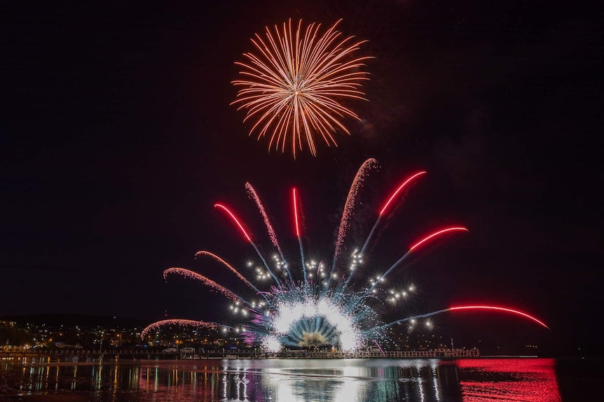 Dark night sky with pink fireworks covering the sky.