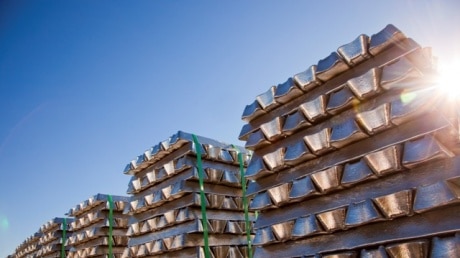 Aluminium ingots stacked up with sun shining through.