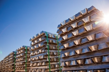 Aluminium ingots stacked up with sun shining through.