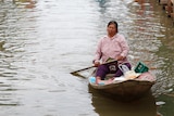 People make their way through a flooded street in the Thai town of Sena