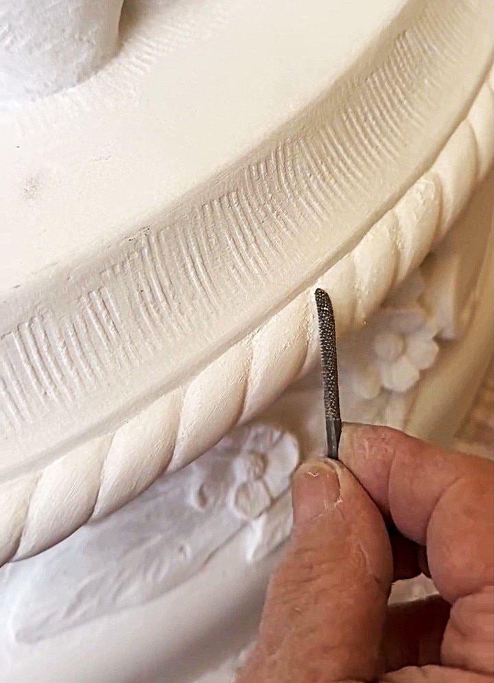 Primer plano de un escultor trabajando en los detalles de una obra de arte.