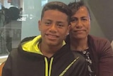 A teenage boy (L) with his mother