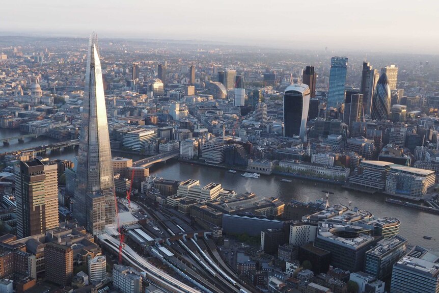 View from a hot air balloon flying over the city of London with views of the gherkin, Shard and London Bridge station.