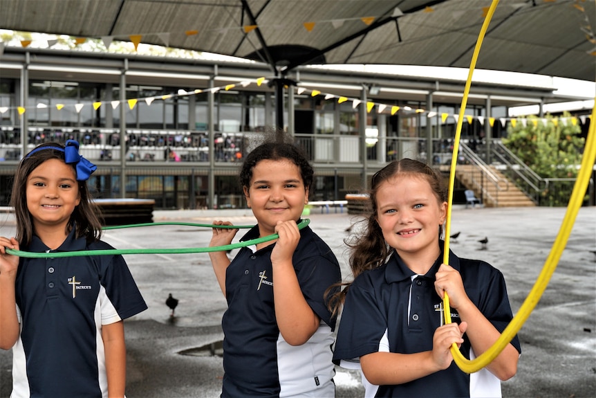 A young Syrian girl and some Australian girlfriends with hoola hoops in a playground.